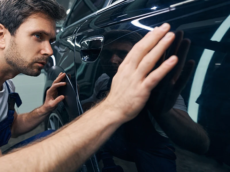 5 corners Isuzu Truck Technician examining vehicle body